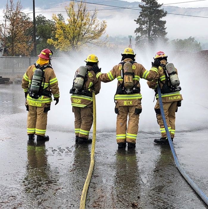 Fire fighters with hoses spraying water 