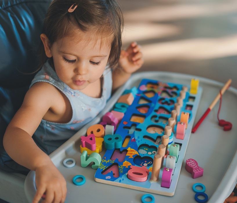 Young child playing with educational toys 