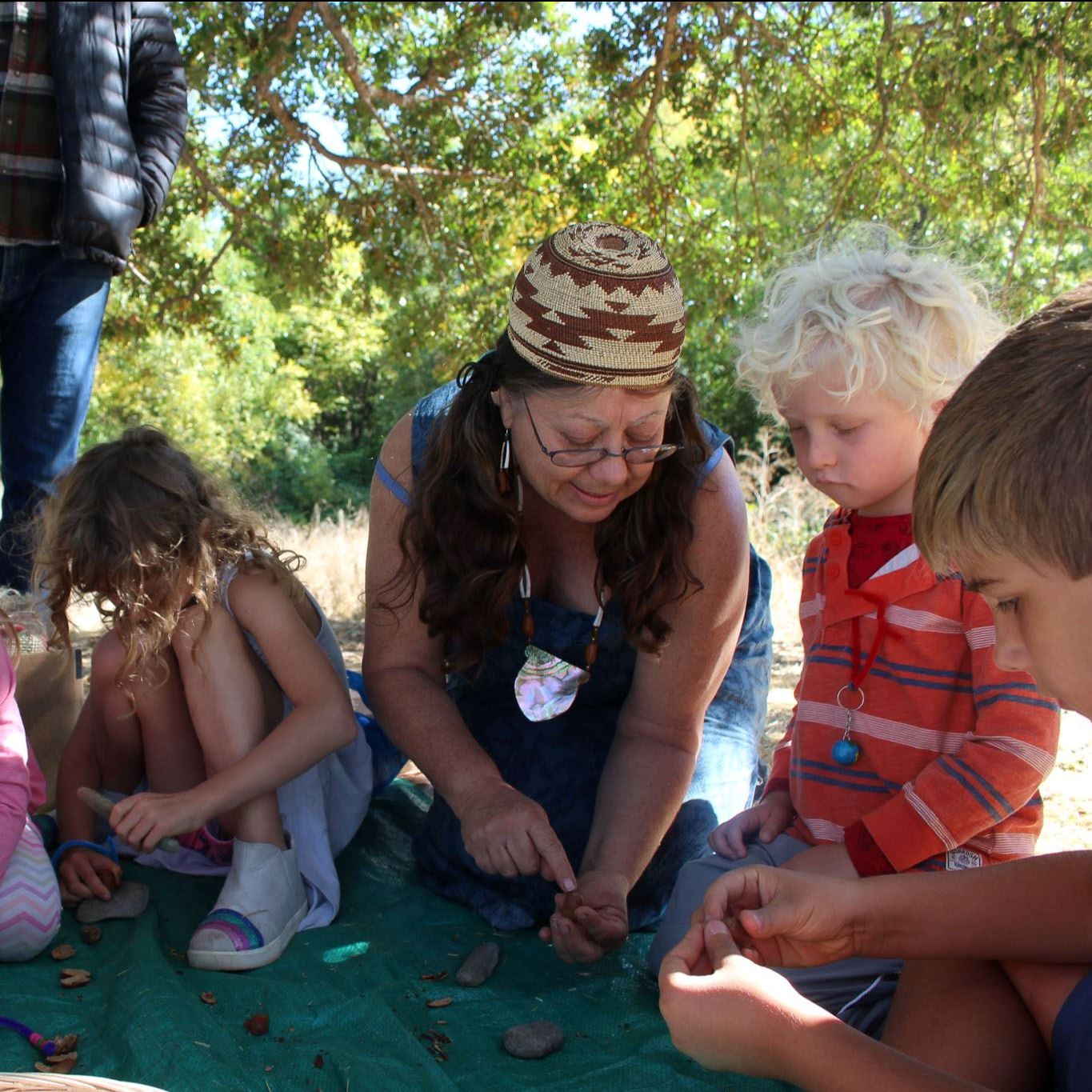 Tribal elder teaches kids about acorn processing