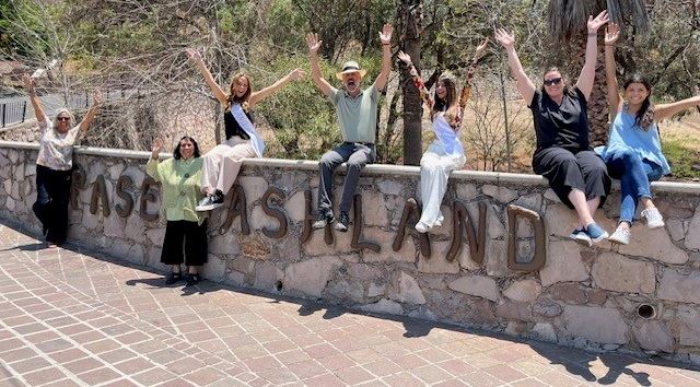People on a city wall in Guanajuato, waving to the camera